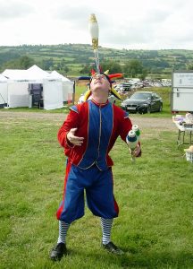 Joey the Juggler balancing a club on his nose